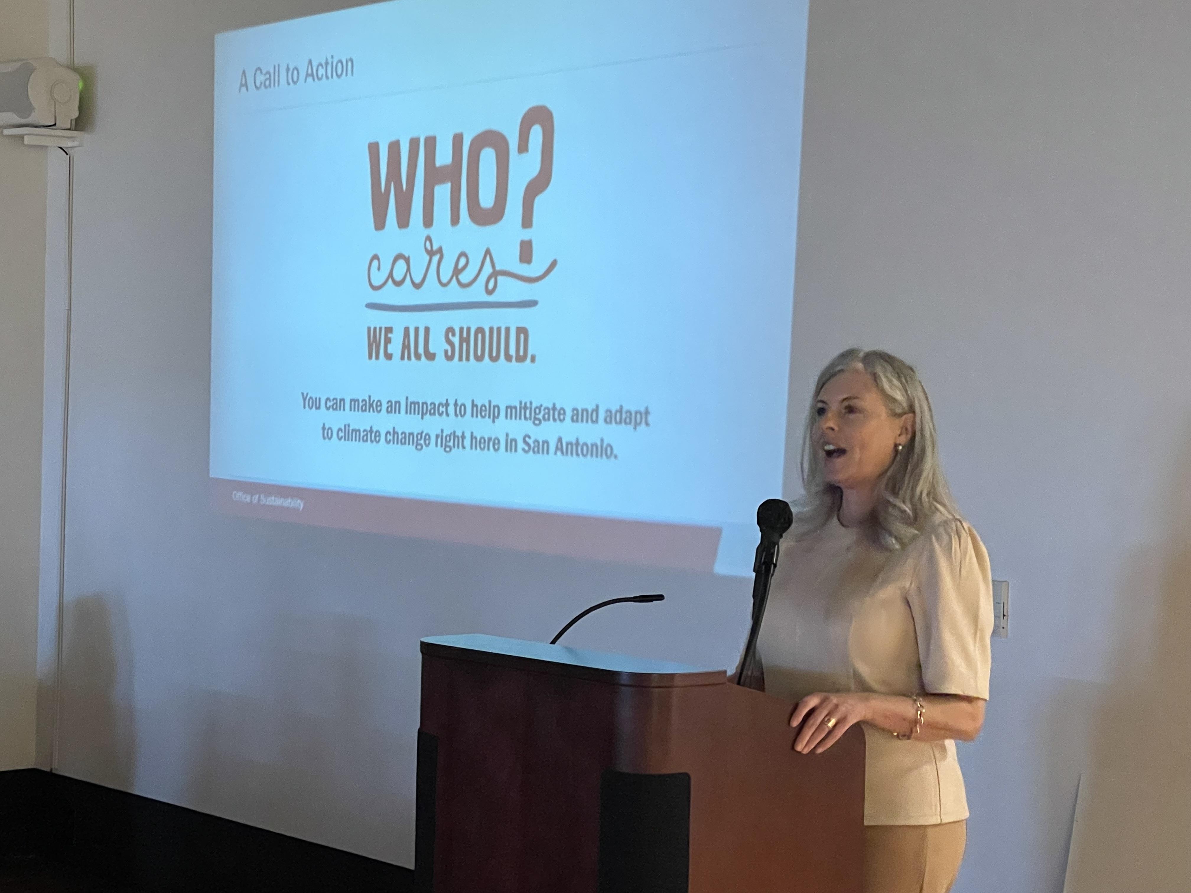 a person standing at a podium with a presentation behind them that reads "Who cares? we all should"