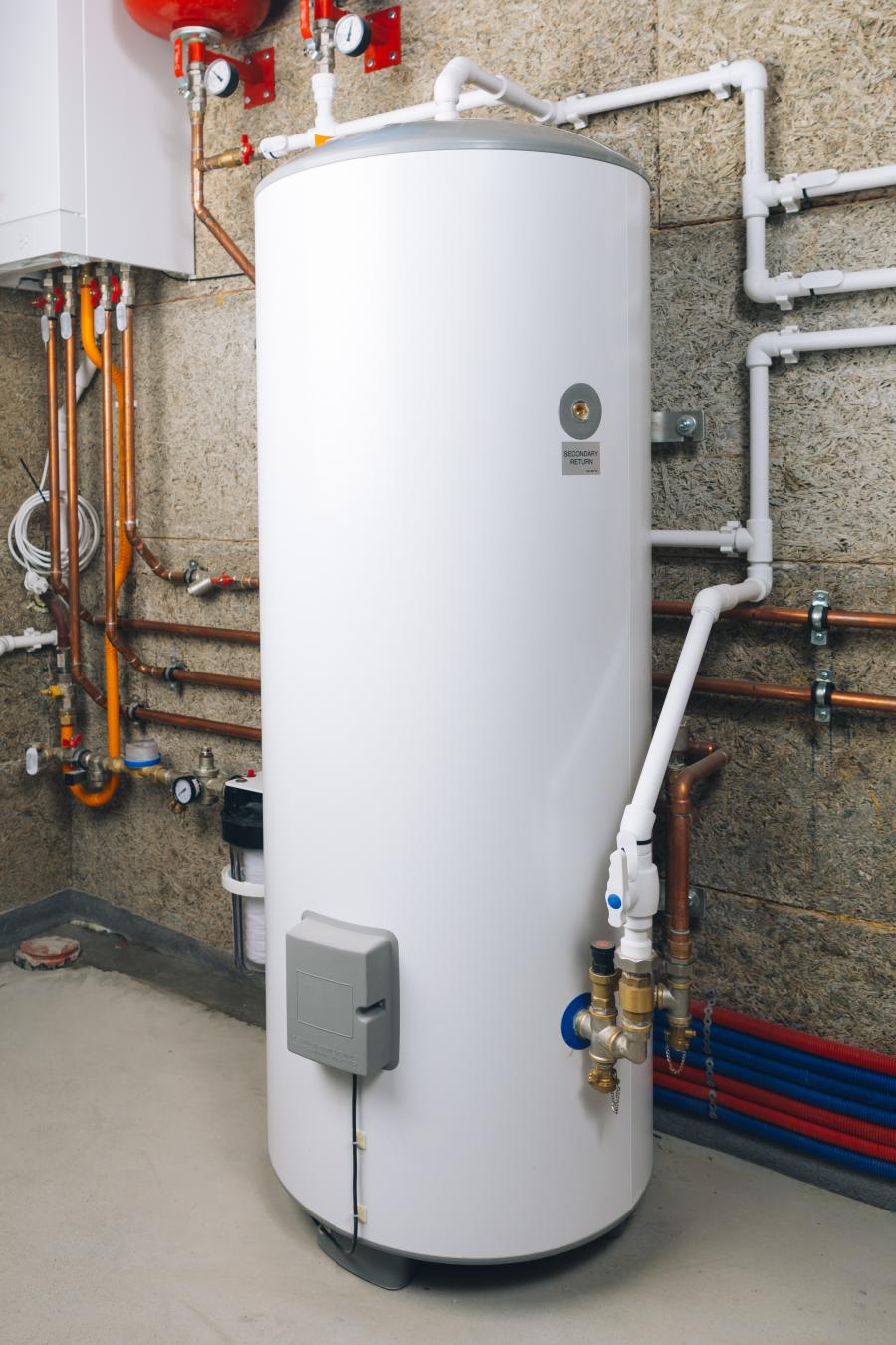 a photo of a white water heater and lots of pipes in the background