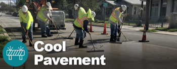 Construction workers spreading cool pavement materials onto a residential street