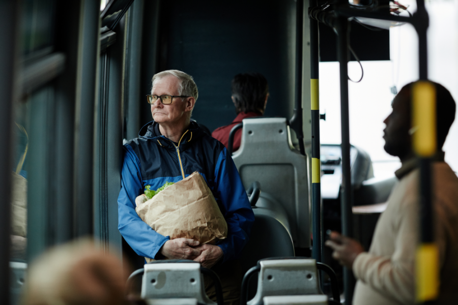 a person sitting on a bus holding groceries