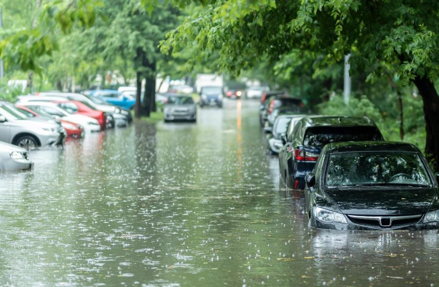 cars half submerged in water parked along a flooded street