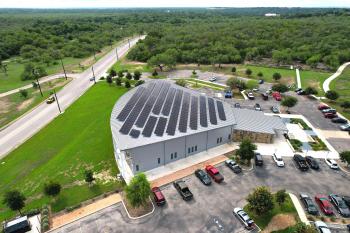 aerial image of a large building with many solar panels on the entire roof