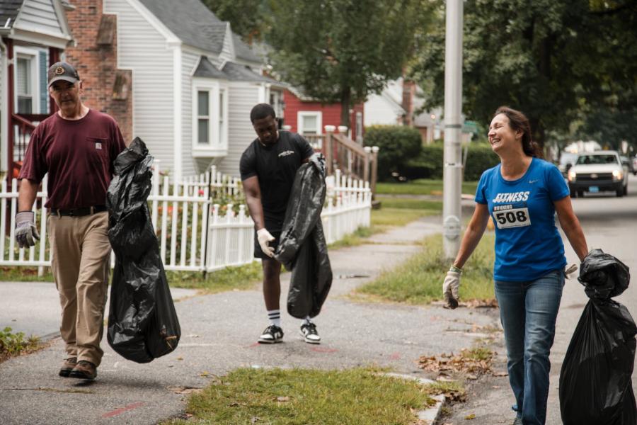 Three volunteers pick up trash