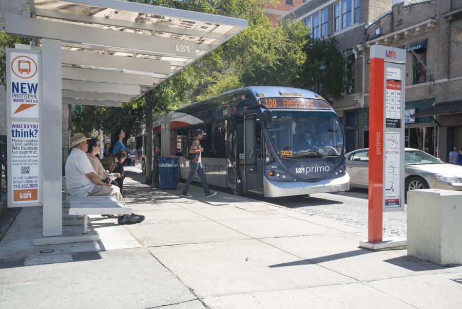 a person boarding a bus stopped at a covered bus stop in a downtown setting