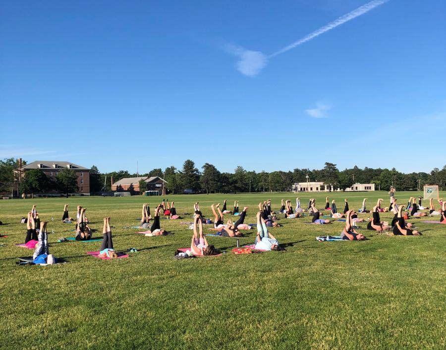 People are pictured participating in a free yoga class at Rogers Field.