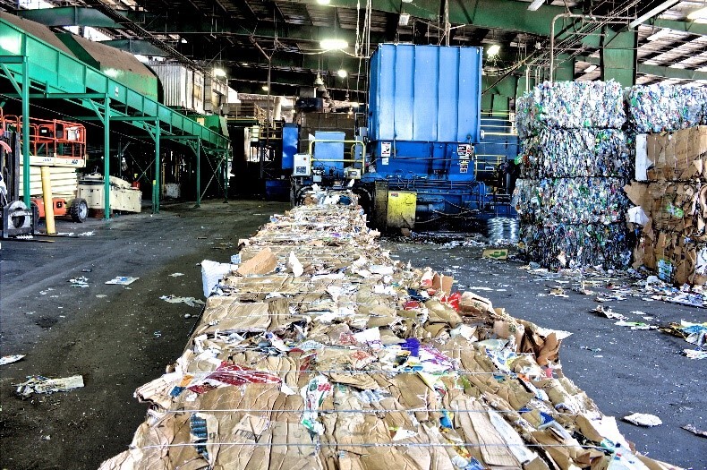 A photo of a waste processing facility with large cubes of compacted waste