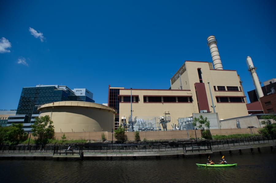 Power plant on edge of a river with two people kayaking