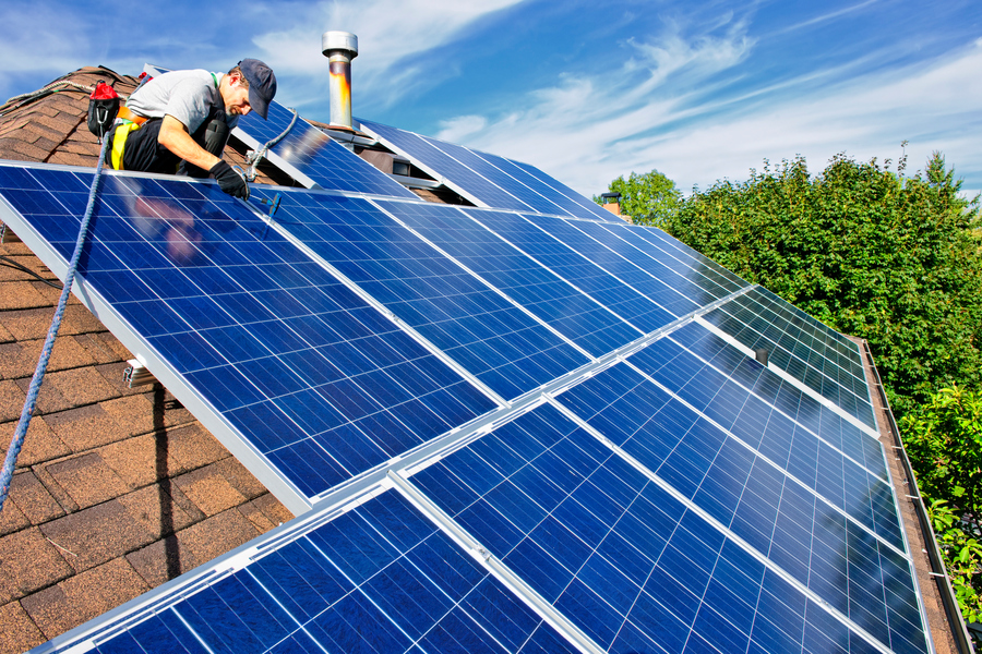 Person working on solar panels on a rooftop