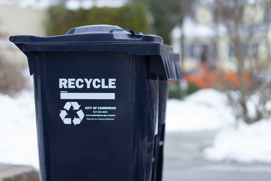 Image of a dark blue recycling bin against a blurred streetscape