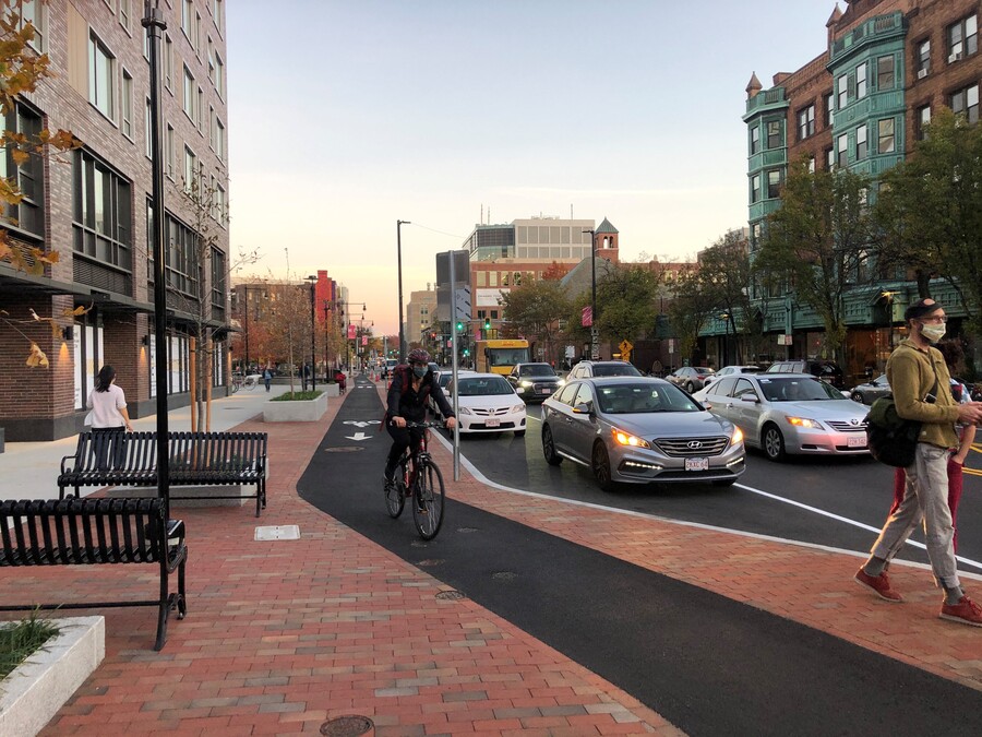 Image of person riding a bike in a separated bike lane on a busy street