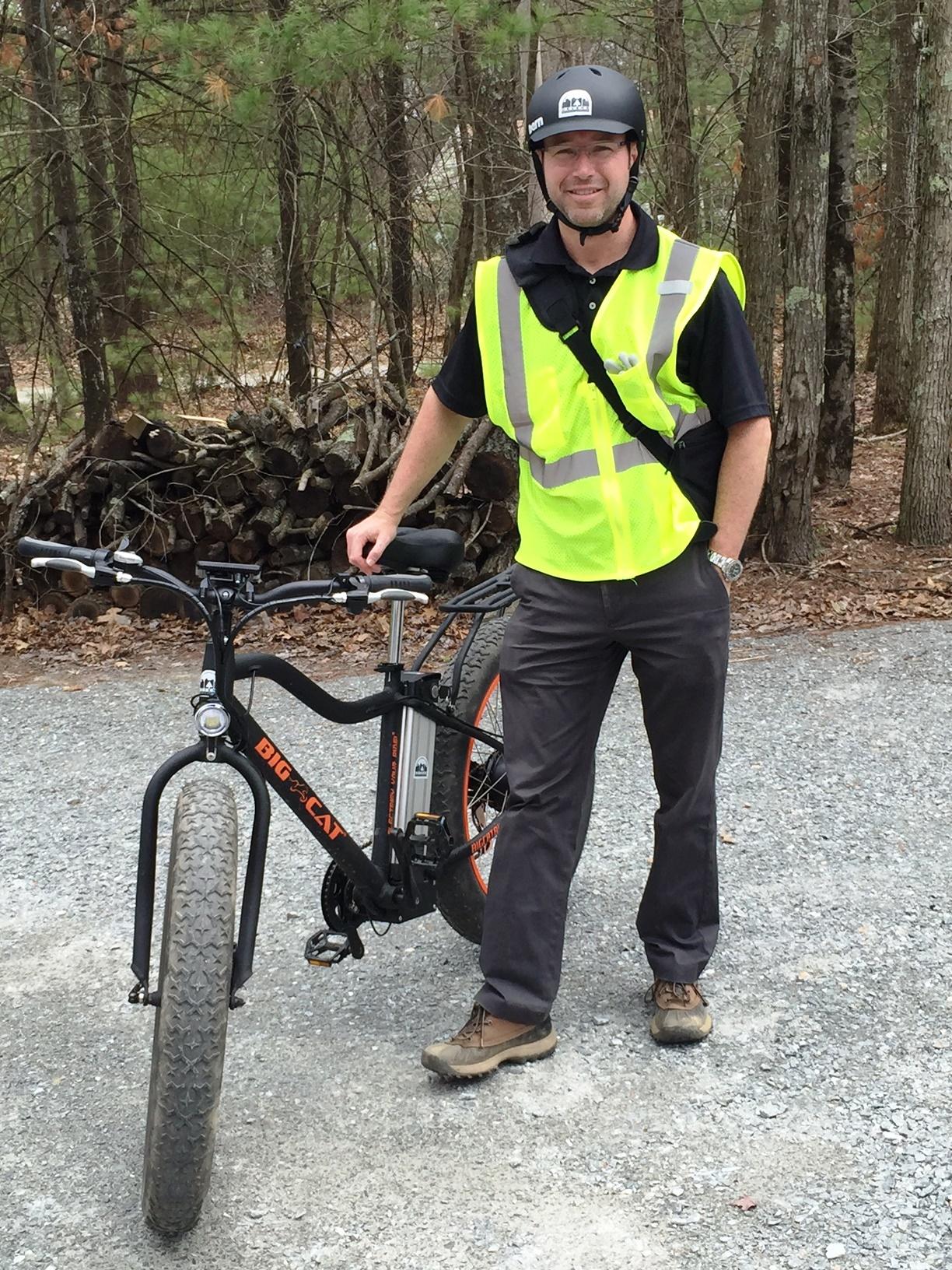 Neil is pictured standing next to a DEC electric bike.