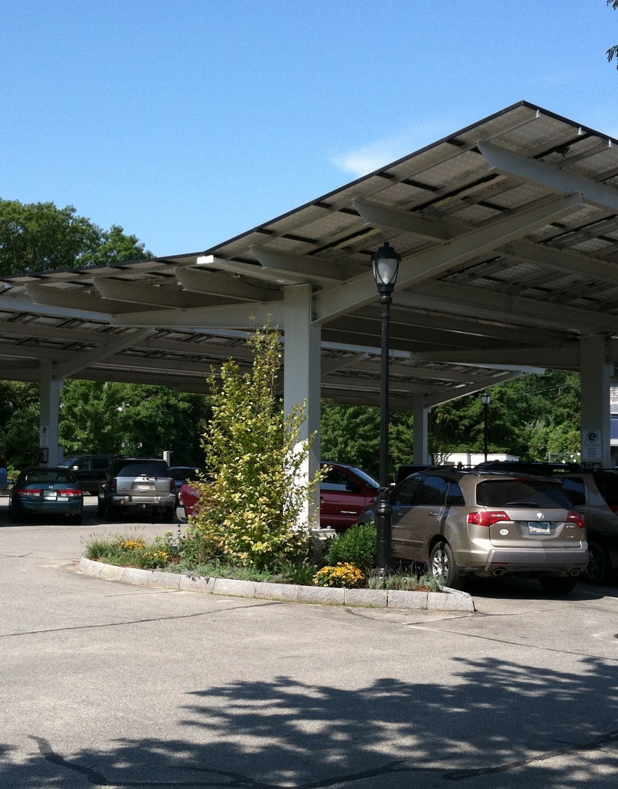 Solar panels provide shade for a parking lot.