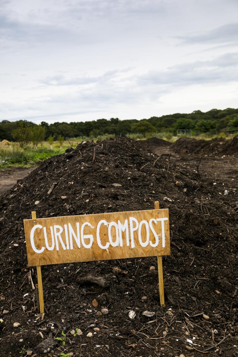 Sign in front of a large pile of finished compost.