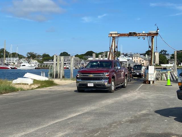 Truck hauling a boat out of the ocean at a boat ramp.