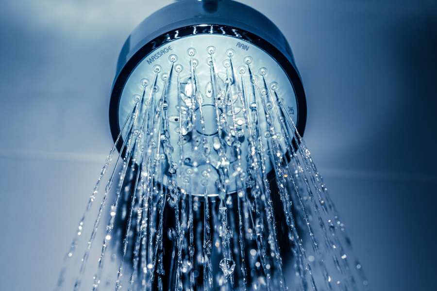 close up of a shower head spraying water