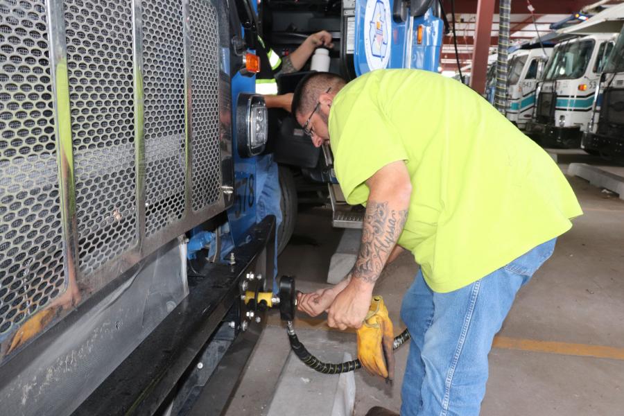 A man filling a vehicle with compressed natural gas at a filling station.